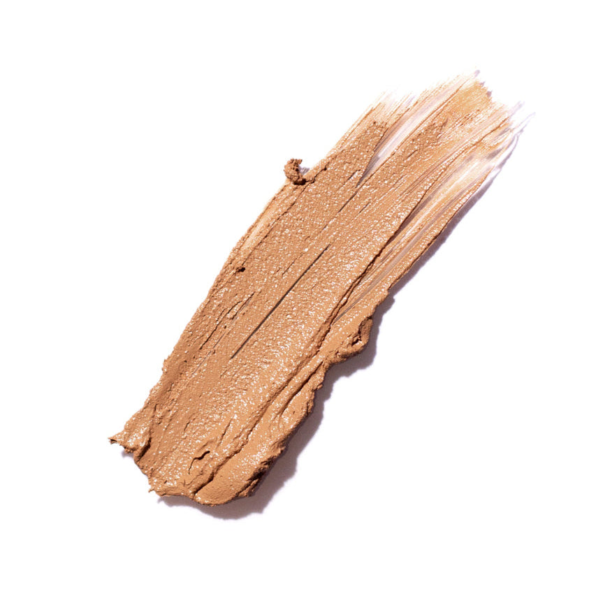 Swatch of brown makeup cream on a white background